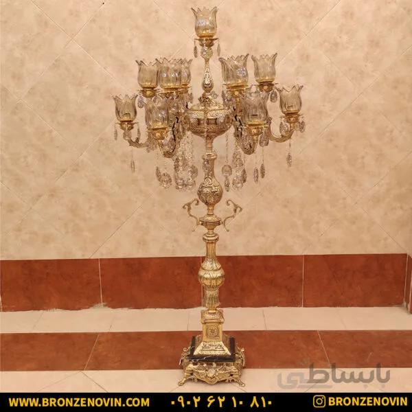 آباژور برنزی ایستاده کنار سالنی دو گل بزرگ پایه سنگی