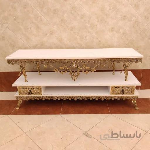 میز تلویزیون برنزی صفحه هایگلاس تسمه پنج گل تاج دار