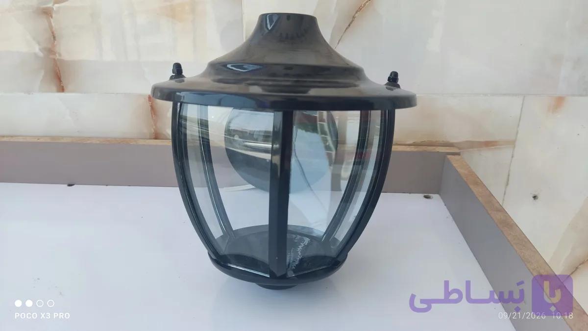 چراغ دیواری فضای باز با بدنه فلزی و حباب شیشهای رنگ مشکی